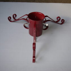 Red metal Christmas tree stand adjustable to the size of the tree using screws